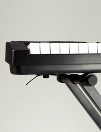 Close-up of a keyboard on a stand against a plain background.