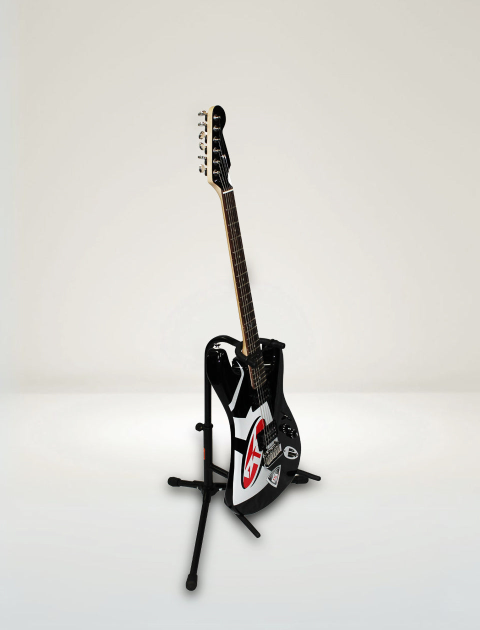 Guitar on a stand against a plain background
