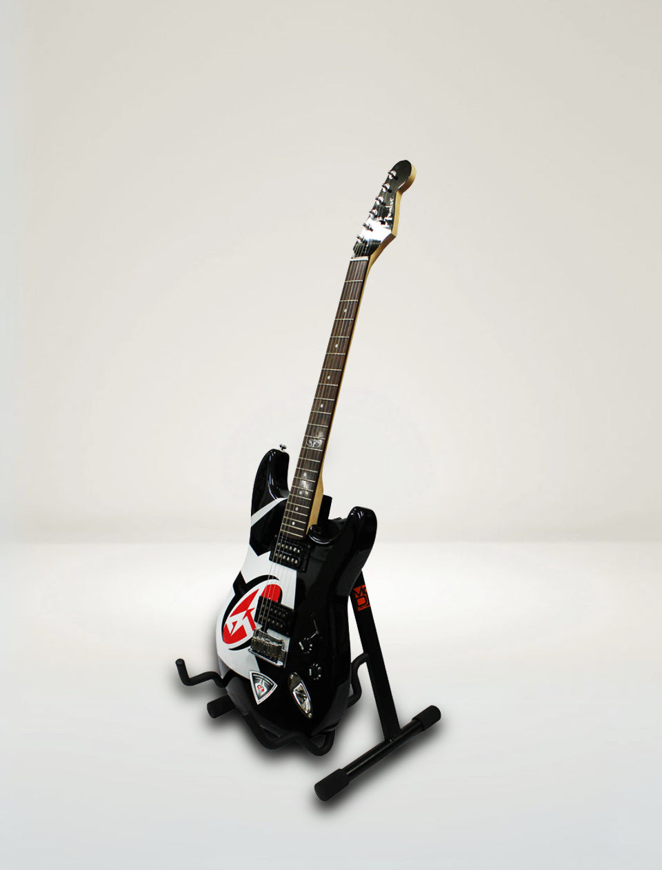 Gaming controller shaped like a guitar on a stand against a plain background