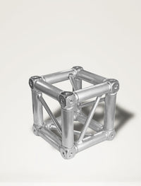 A silver universal corner junction block with a metallic finish, used for connecting truss elements in a audio and visual equipment setup.